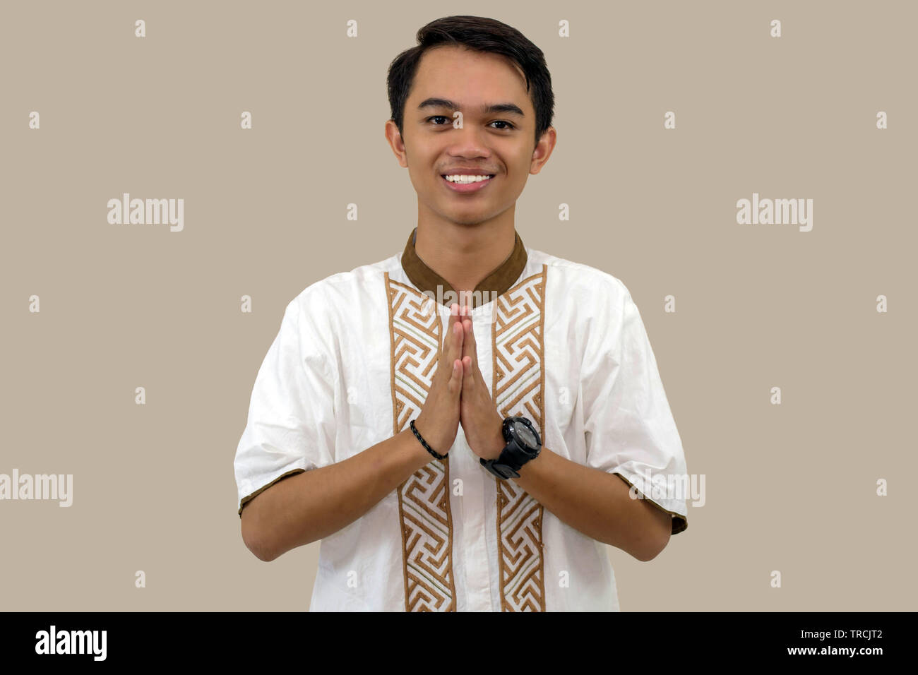 Ritratto di uomini musulmani congratularmi con l'Eid al-Fitr celebrazione davanti a una telecamera isolata su sfondo marrone Foto Stock