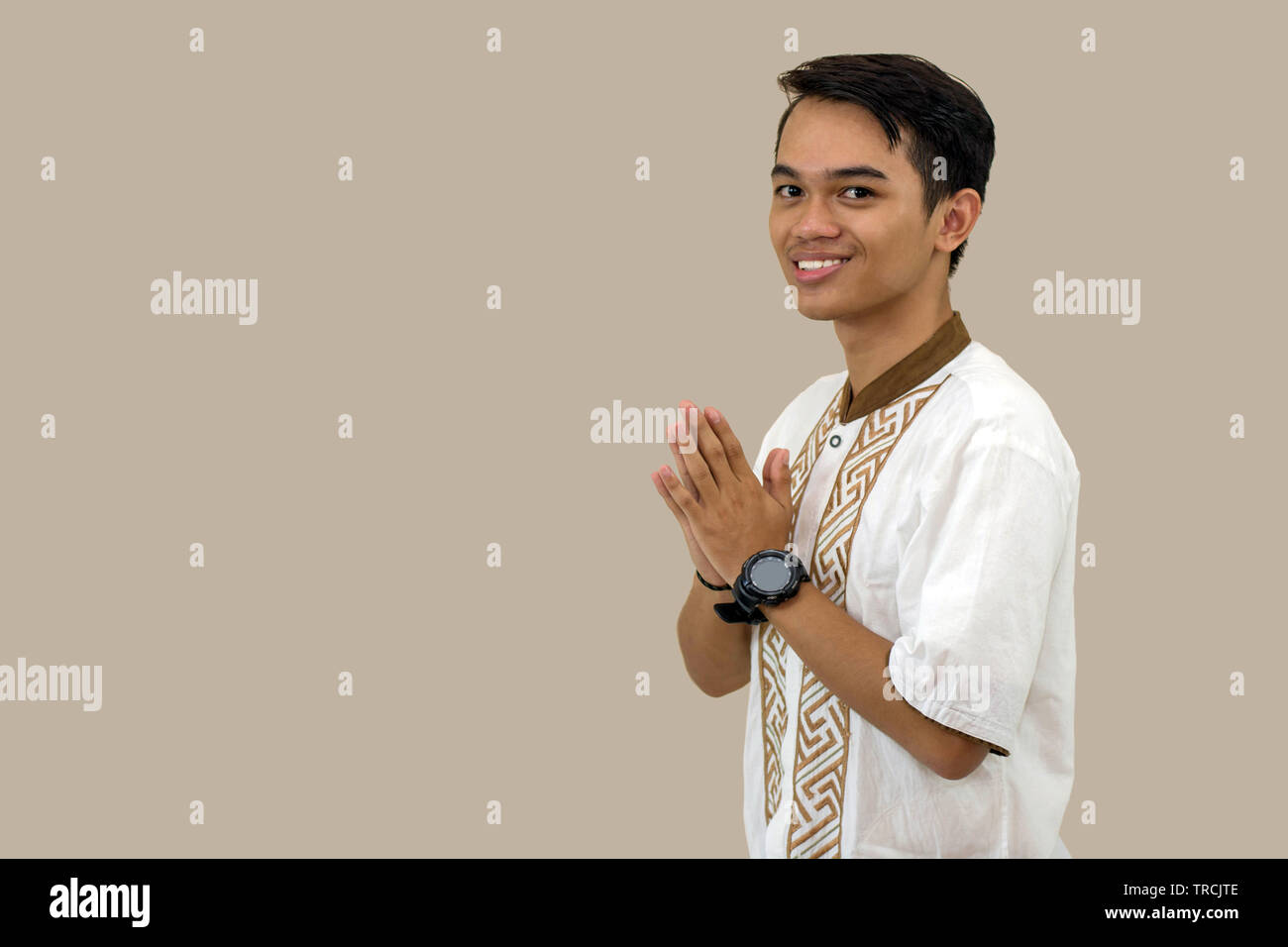 Ritratto di uomini musulmani congratularmi con l'Eid al-Fitr celebrazione davanti a una telecamera isolata su sfondo marrone Foto Stock