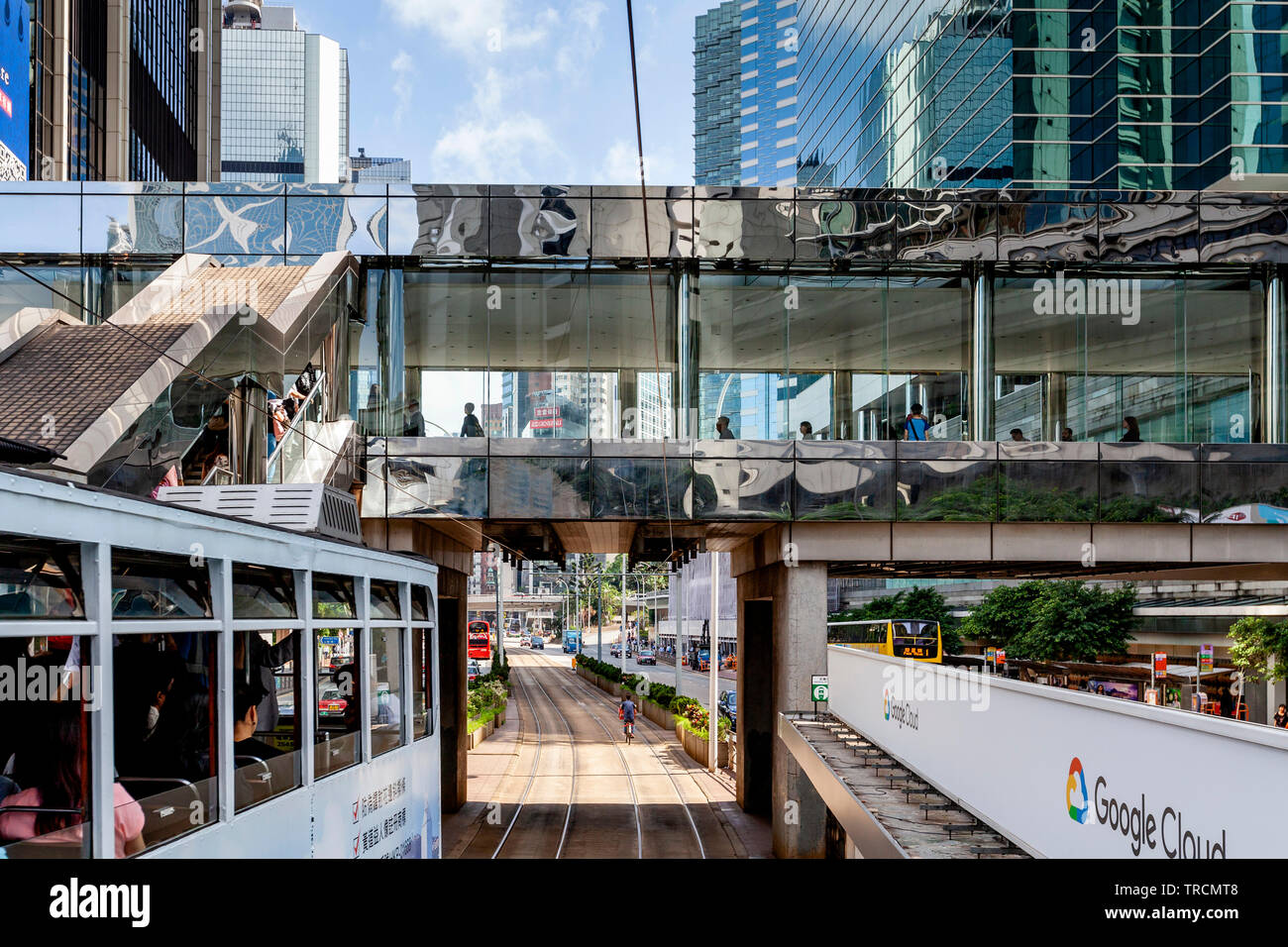 Il tram passa sotto un cavalcavia pedonali, Hong Kong, Cina Foto Stock