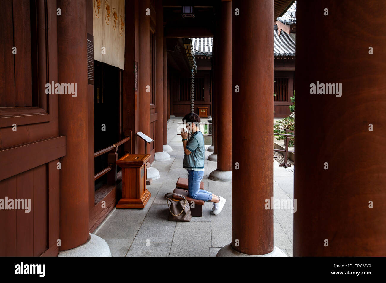 Una donna orante presso il Chi Lin Monastero, Hong Kong, Cina Foto Stock