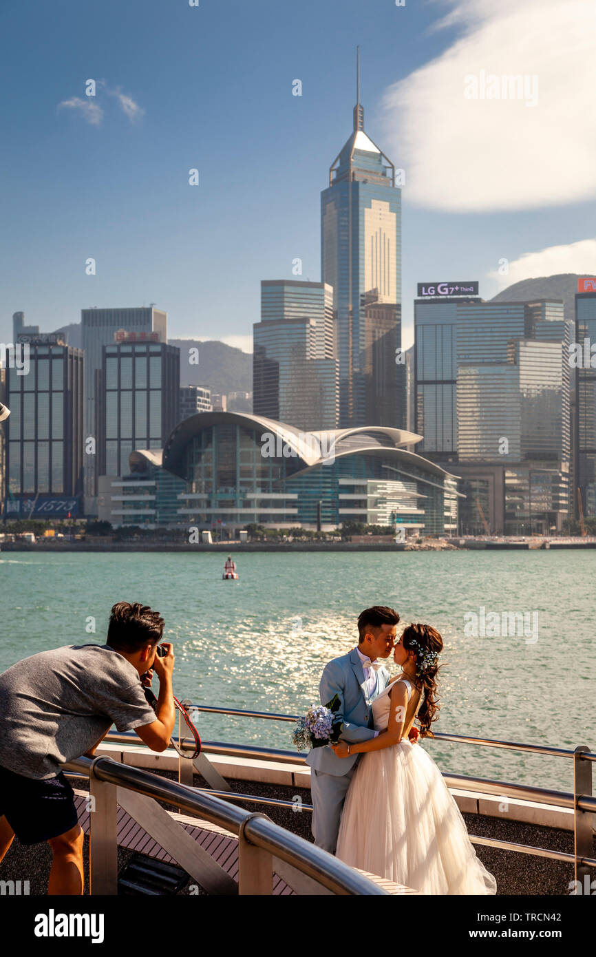 Un 'appena sposato' giovane posa per fotografie in Tsim Sha Tsui Promenade, Hong Kong, Cina Foto Stock