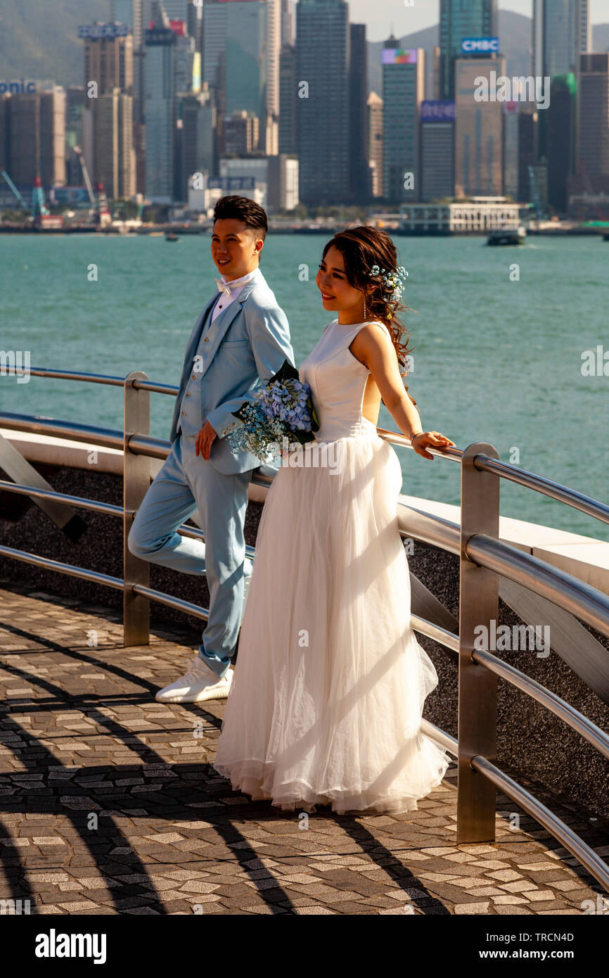 Un 'appena sposato' giovane posa per fotografie in Tsim Sha Tsui Promenade, Hong Kong, Cina Foto Stock