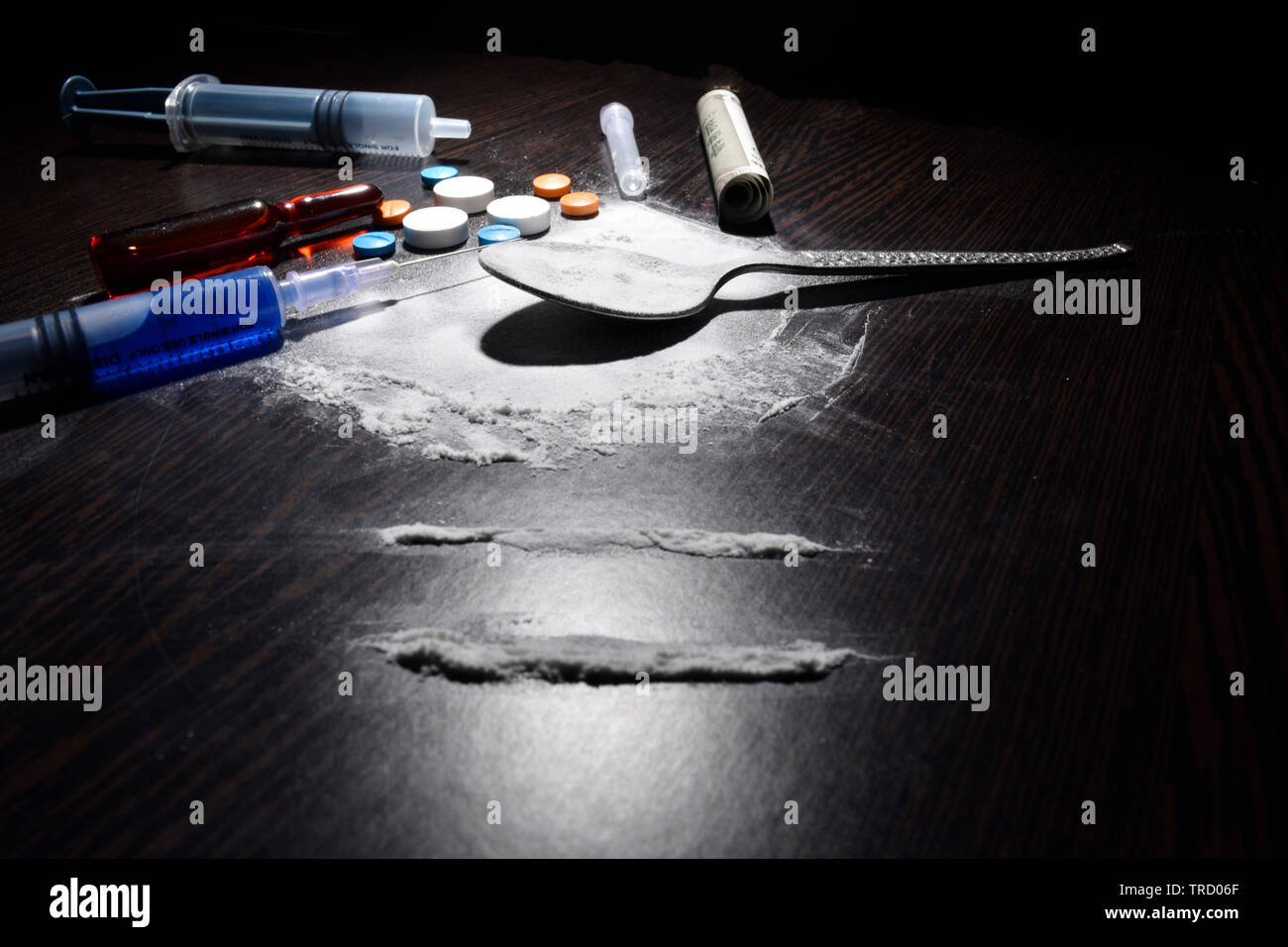 Il concetto di droga, cocaina, iniezione,tabella, cucchiaio sul tavolo scuro Foto Stock