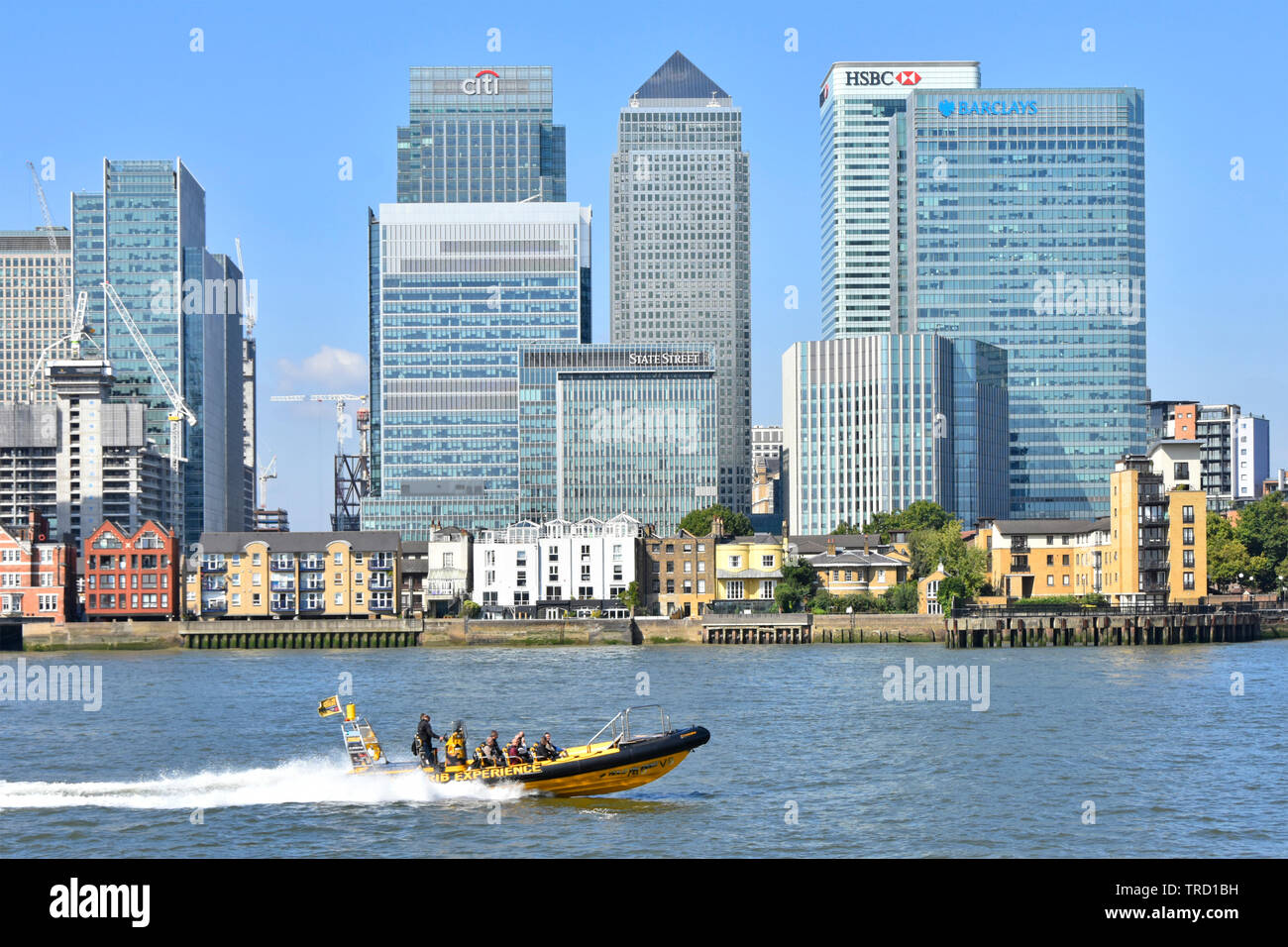 Thames esperienza di nervatura turisti speedboat passando moderno grattacielo landmark edifici sul Canary Wharf, Isle of Dogs London Docklands skyline England Regno Unito Foto Stock