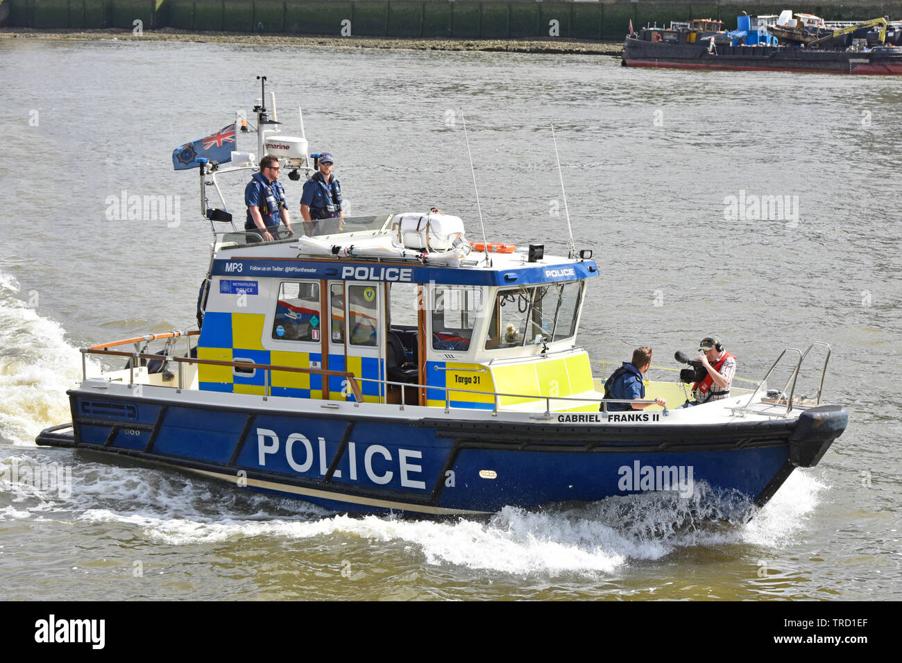 Cameraman riprese incontrato funzionario di polizia equipaggio a bordo la Metropolitan Police Marine unità di polizia risposta veloce Targa 31 barca Pool di London River Thames Regno Unito Foto Stock