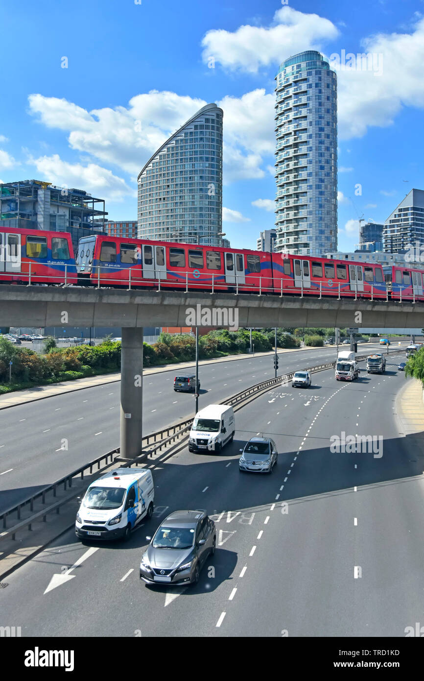 East End alto grattacielo appartamento edificio che domina il treno sulla ferrovia leggera Docklands viadotto sopra il traffico su strada Tower Hamlets London REGNO UNITO Foto Stock