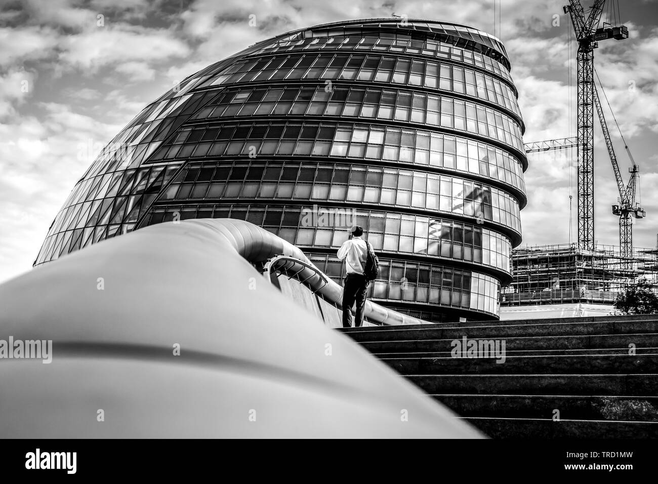 Uomo in piedi sui gradini della City Hall Londra Foto Stock