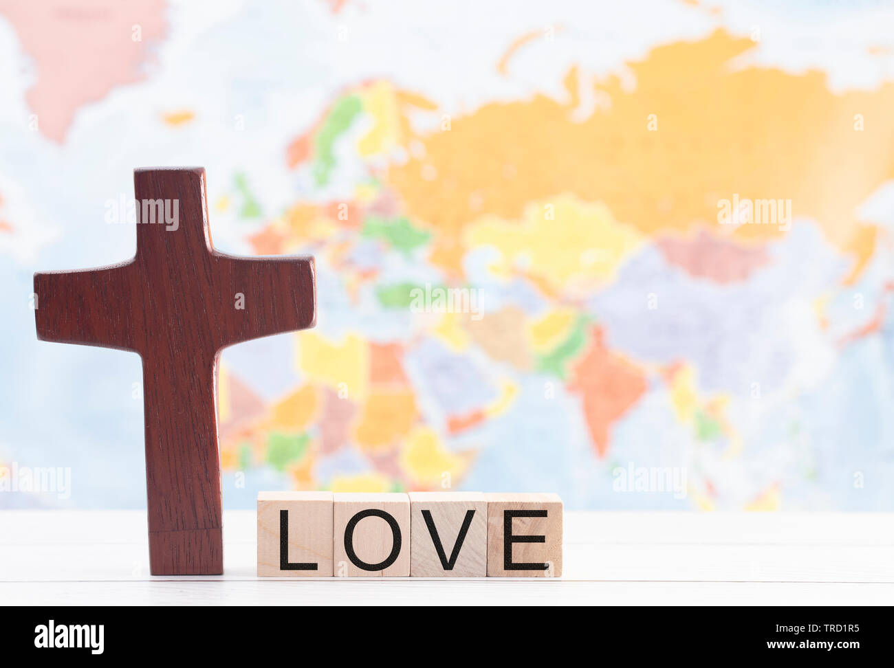 L amore e la croce di Cristo con il mondo sullo sfondo Foto Stock