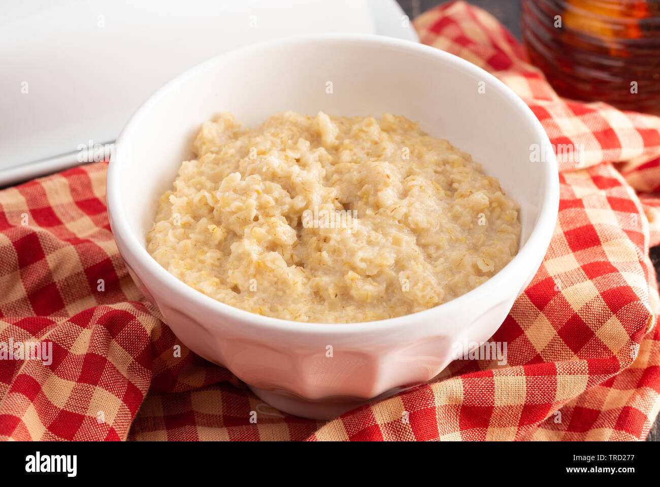 Plain Farina di avena su un tavolo di legno con rosso a scacchi Tovaglia Foto Stock