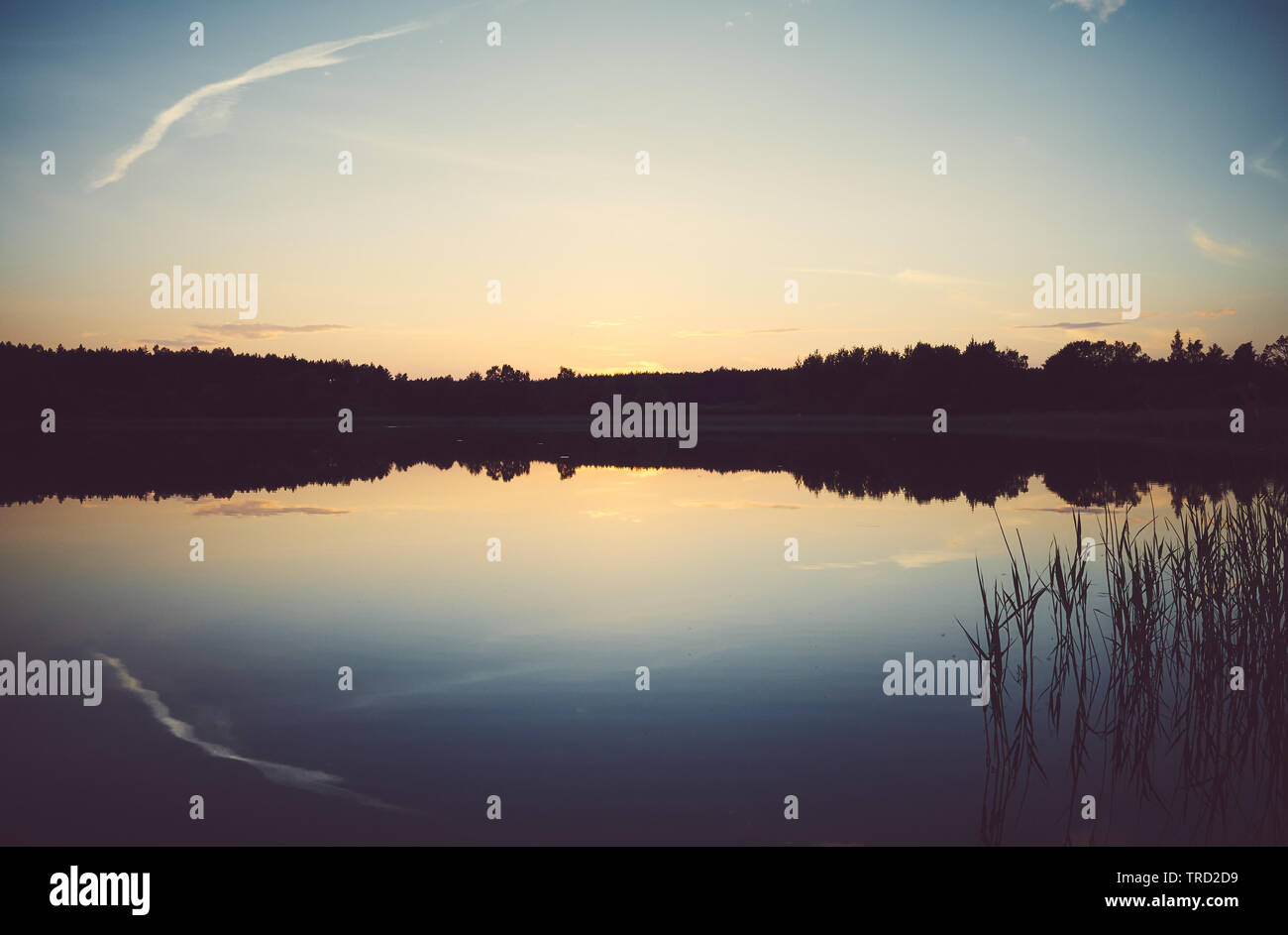 Scenic tramonto riflesso in un lago calmo, tonificazione del colore applicato, sfondo naturale. Foto Stock
