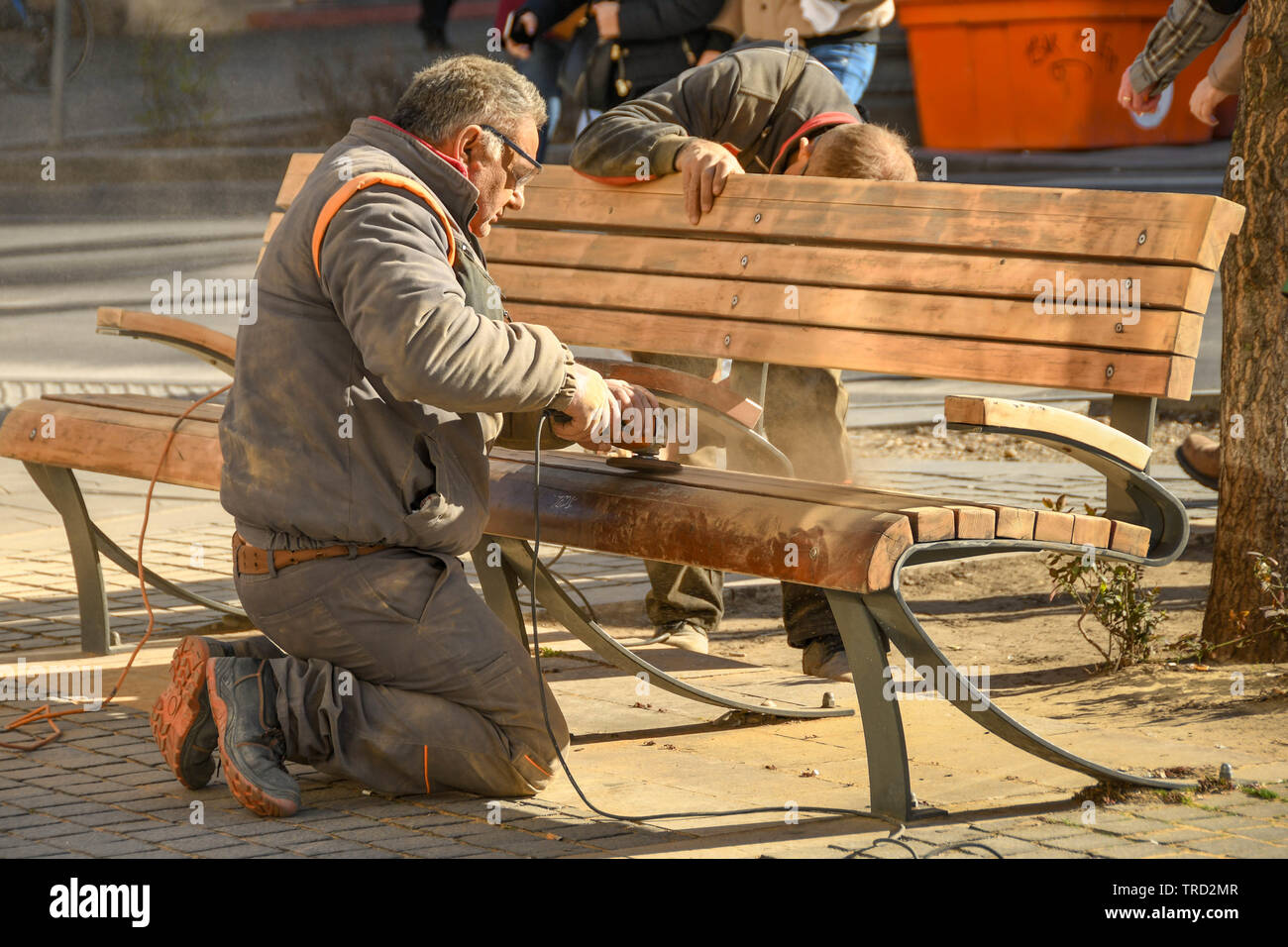 BUDAPEST, UNGHERIA - Marzo 2018: lavoratore verso il basso di levigatura di una panca in legno in Budapest City Center. Foto Stock