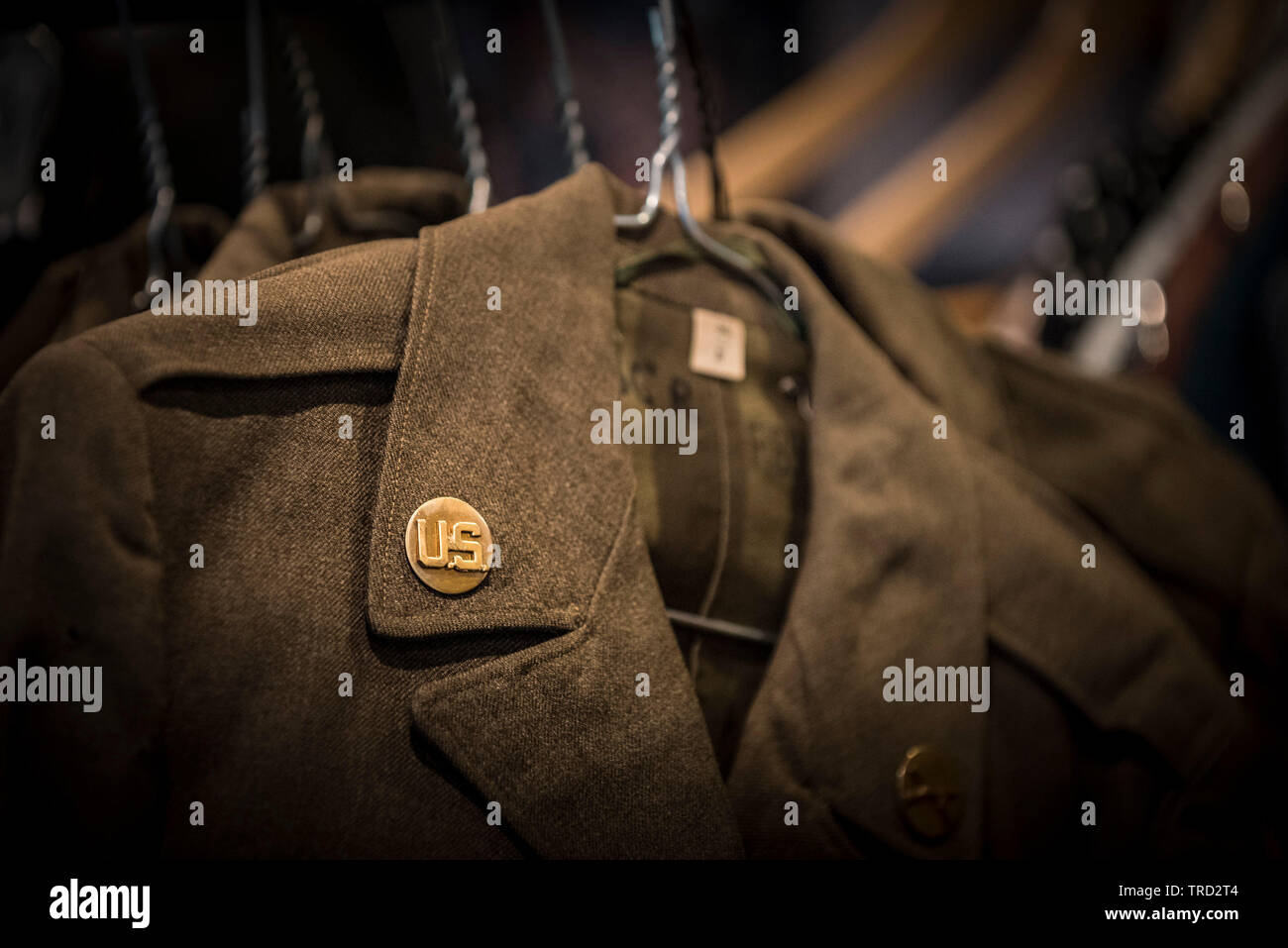Una vista ravvicinata dell'ottone 'uomo arruolato' emblema sulla tunica uniforme di una guerra mondiale II Fante americano. Foto Stock