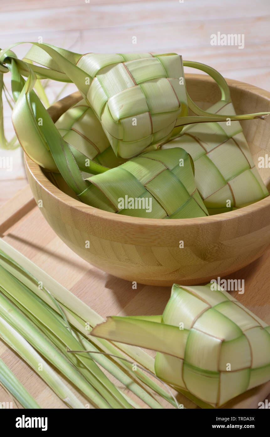 Ketupat, torta di riso a forma di diamante sacchetto costituito da tessuto di foglie di noce di cocco Foto Stock