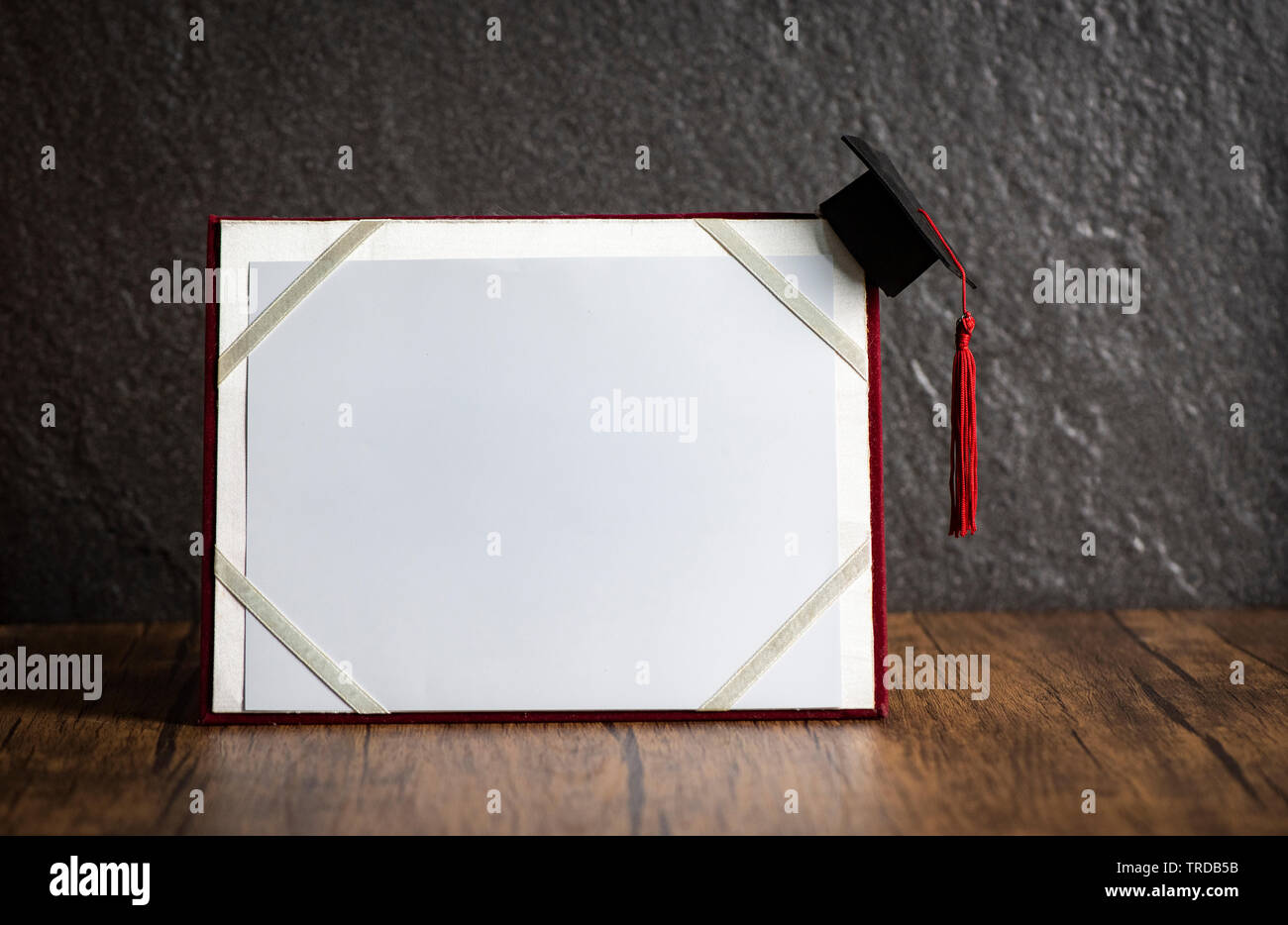 Graduation cap on graduation certificate education concept on wooden with dark background Foto Stock