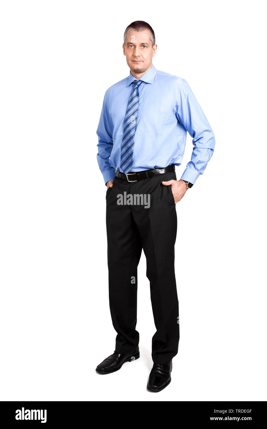 Ritratto di un simpatico imprenditore in un abito grigio pantaloni in piedi con le mani nelle sue tasche dei pantaloni Foto Stock