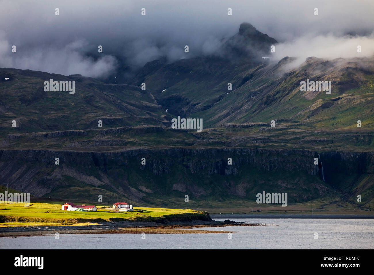 Agriturismo al sole nella parte anteriore del buio del paesaggio di montagna, Islanda, Snaefellsnes, Grindafjoerdur Foto Stock