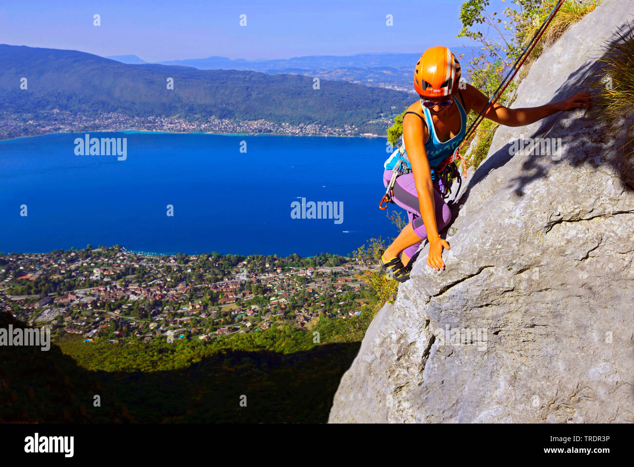 Scalatore femmina su una roccia sopra il lago di Annecy, Francia, Savoie Foto Stock