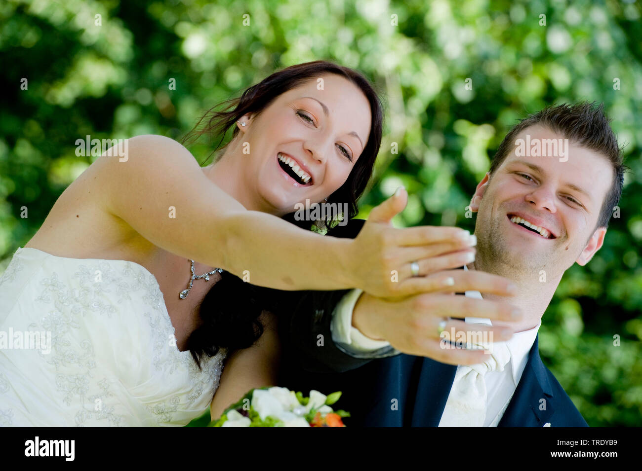 Coppia di sposi mostrando le loro fedi dopo la cerimonia e sorridente Foto Stock