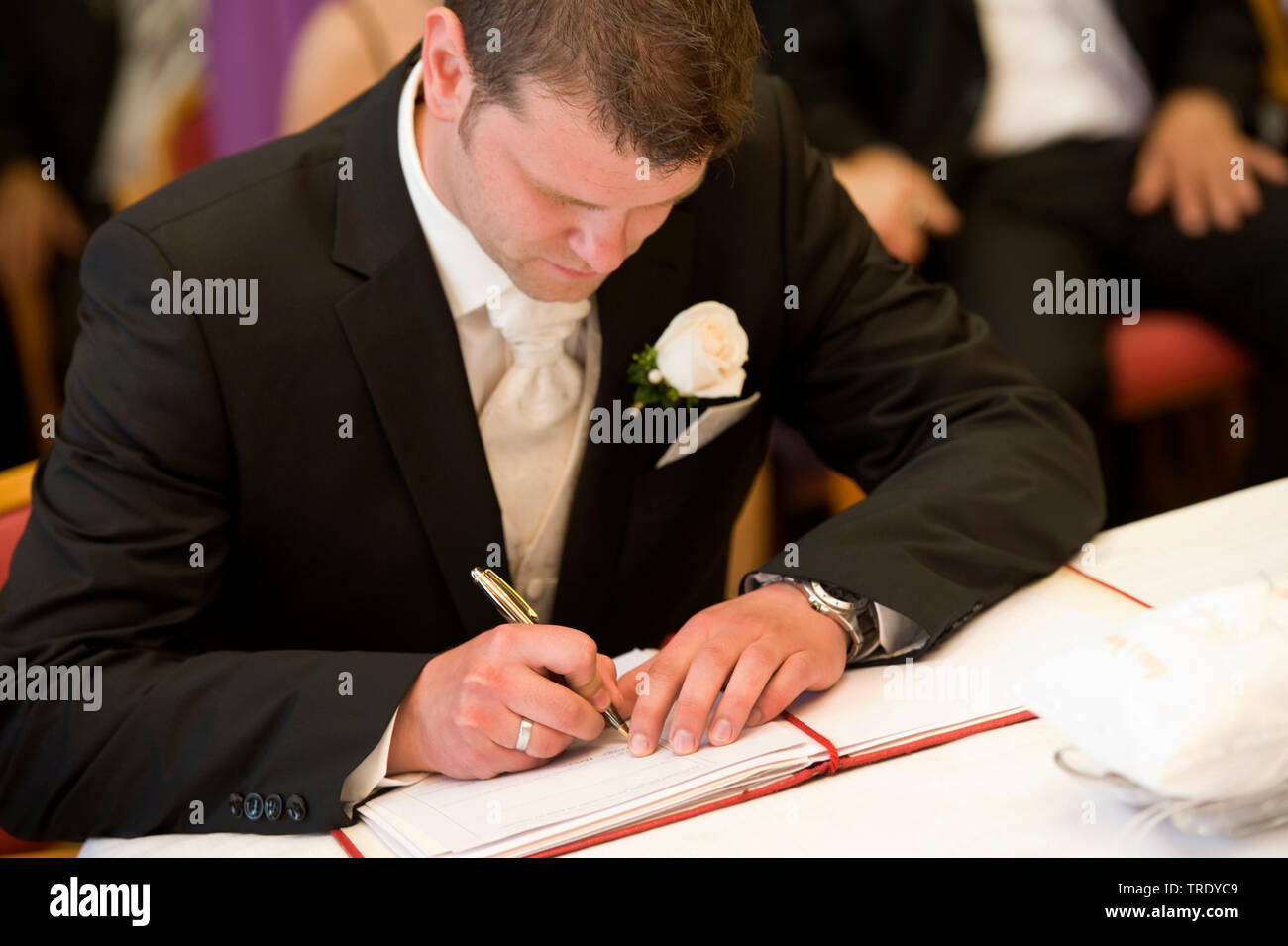 Lo sposo firma nel matrimonio prenota Foto Stock