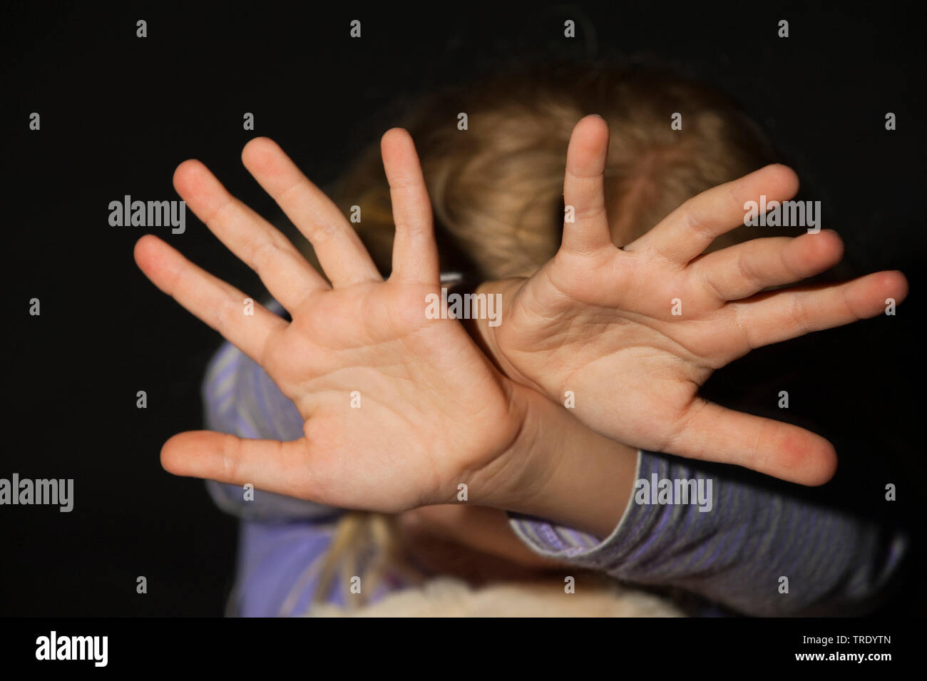 Testa di una giovane ragazza outstreching le braccia per la protezione - abuso di minori Foto Stock