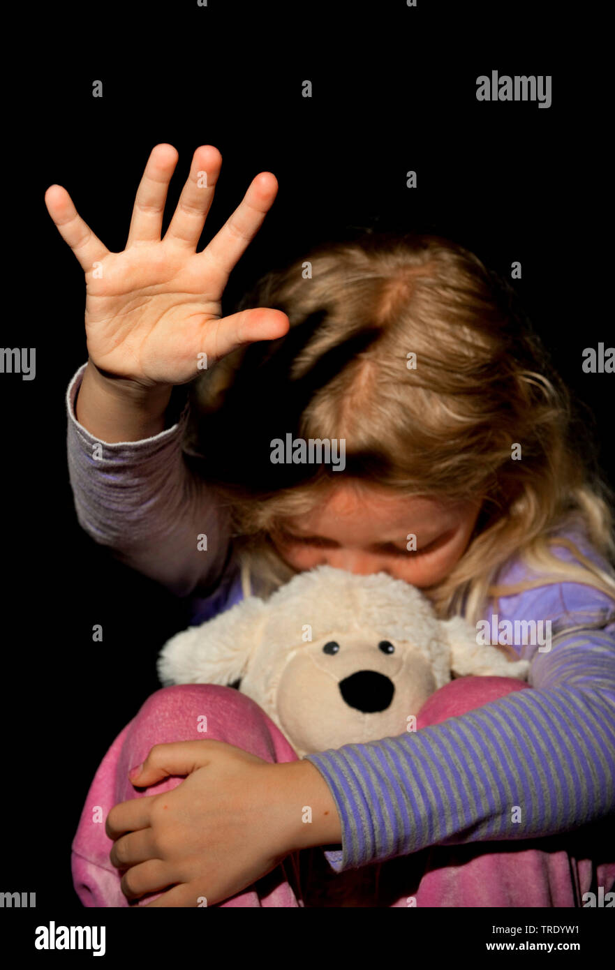 Ritratto di una giovane ragazza, premendo la sua testa in un peluche - abuso di minori Foto Stock