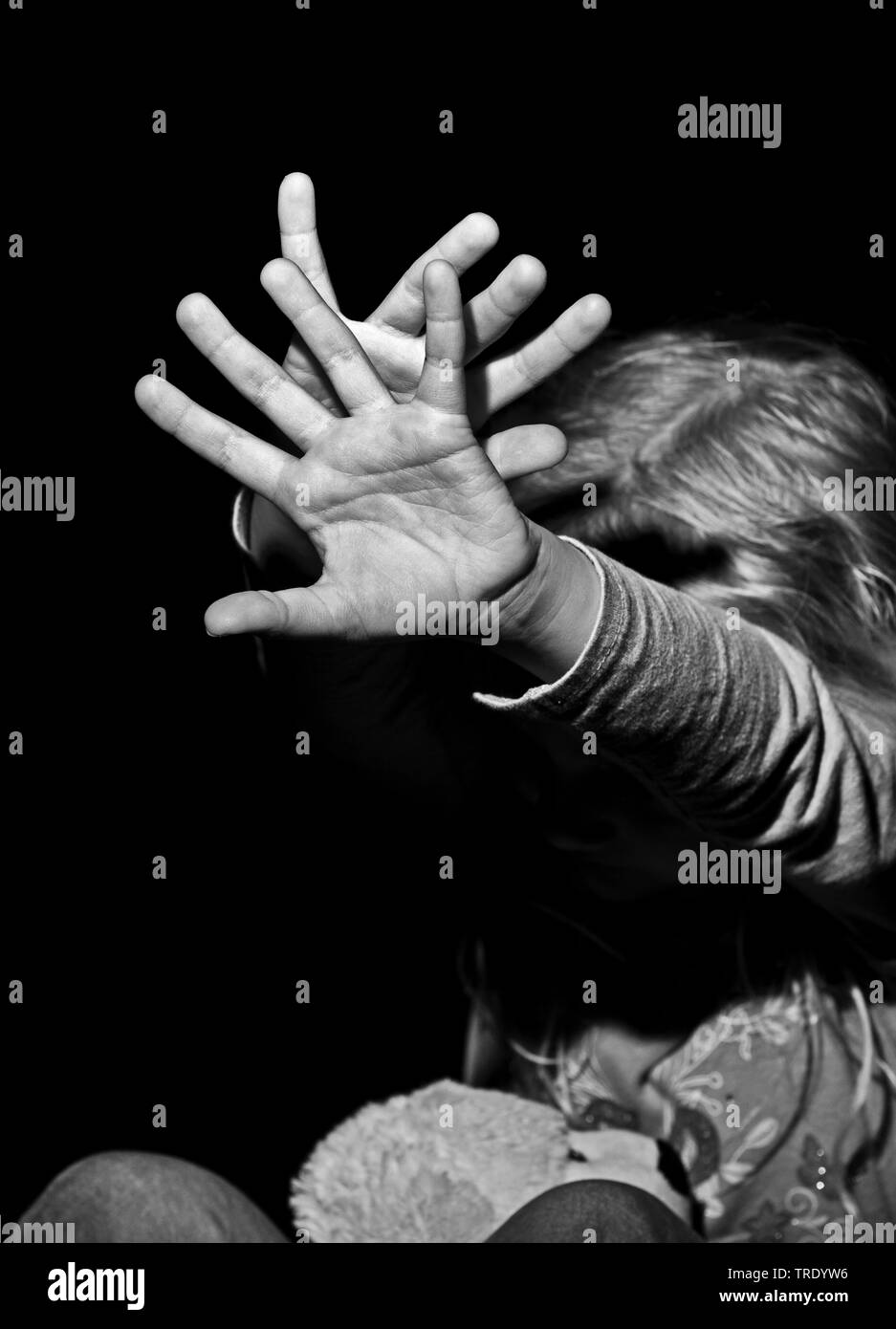 Ritratto di una giovane ragazza outstreching le braccia per la protezione - abuso di minori (in bianco e nero foto) Foto Stock