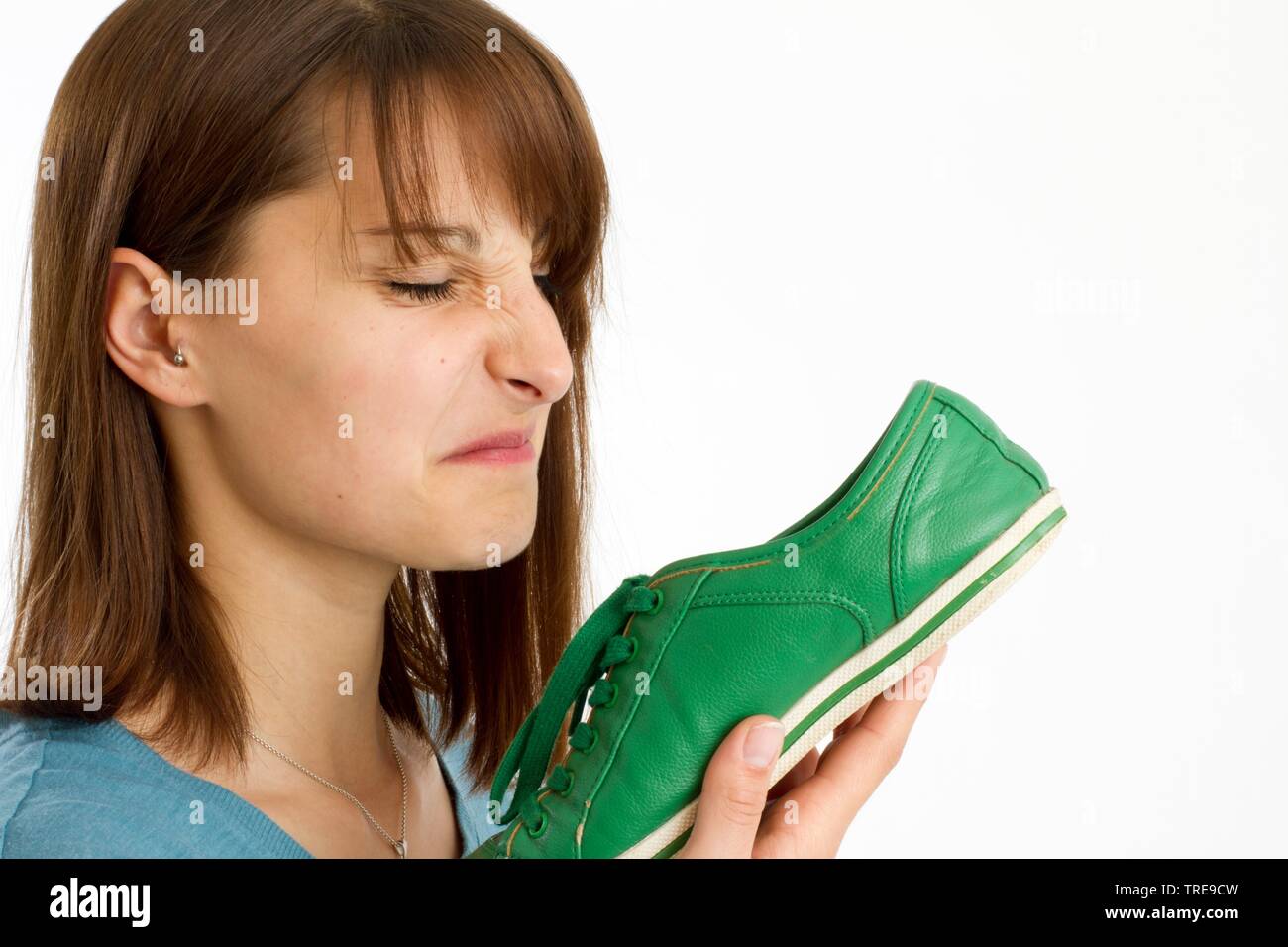 Giovani donne squinching fino il viso maleodoranti in corrispondenza di una calzatura Foto Stock