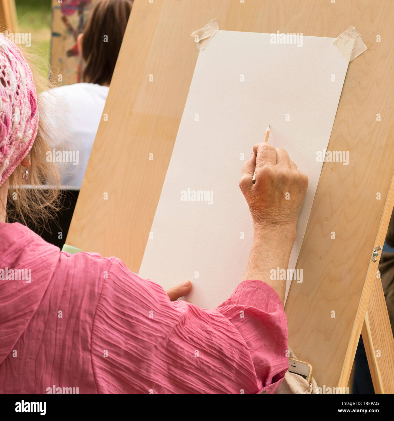 La donna aspira a art studio per persone anziane, cavalletto con fogli di carta bianca. Argomento per la creatività, hobby per i pensionati, programmi sociali per anziani pers Foto Stock