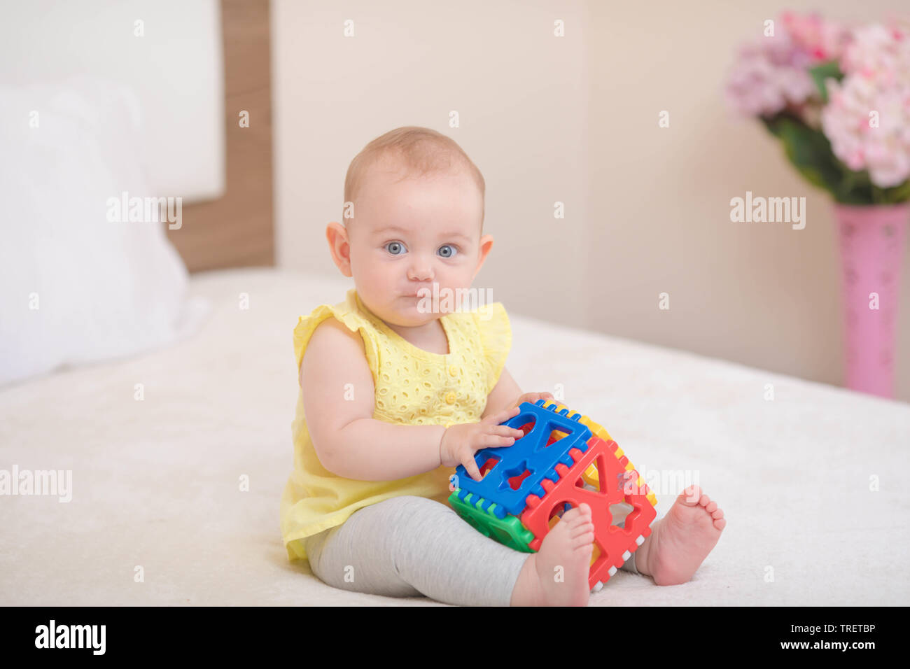 Bello e simpatico baby sitting su letto Foto Stock