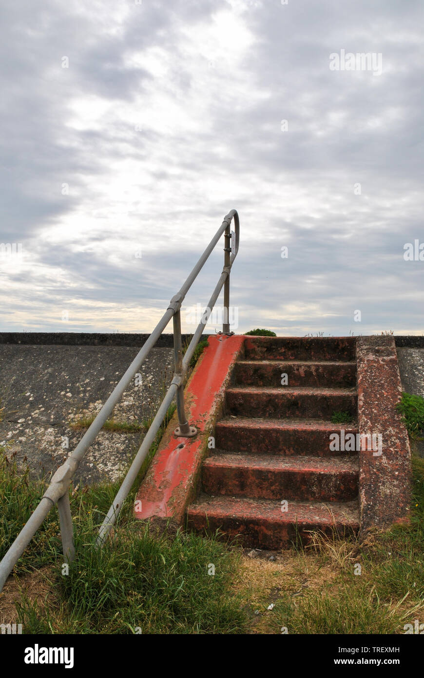 Passi che conducono fino alla promenade set contro il grigio di un cielo nuvoloso Borth, Galles Foto Stock