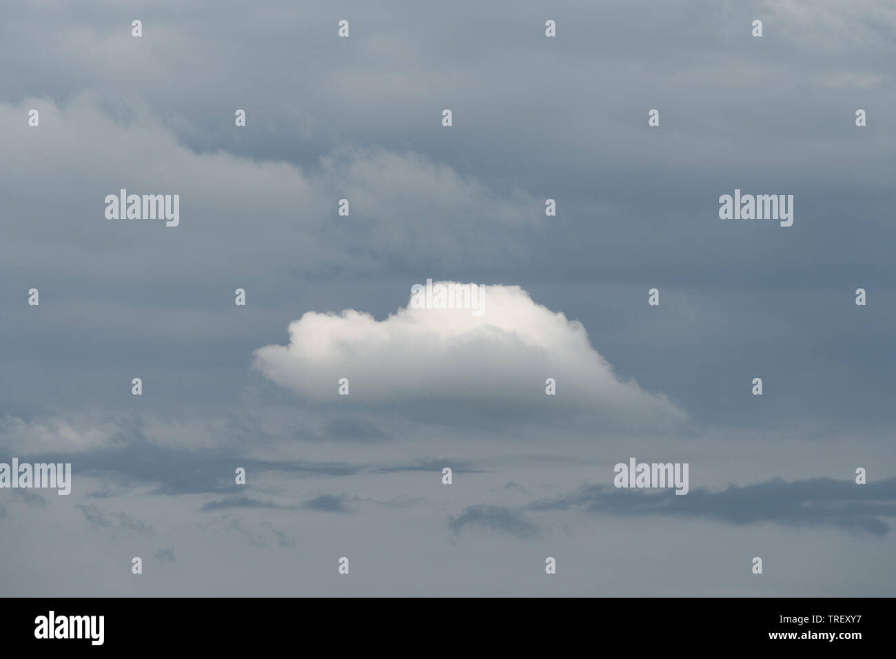Bianco cloud solitario su uno sfondo di nuvole grigio. Bellissimo cielo Foto Stock