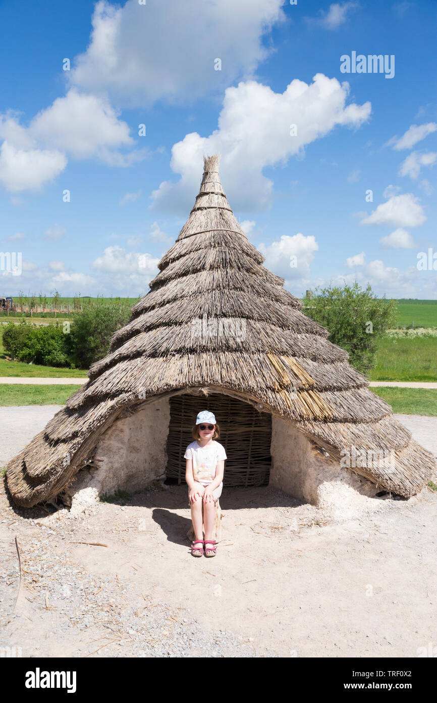 Esterno del ricreato il neolitico Età della pietra hut / stoneage capanne col tetto di paglia / tetti . Esposizione; Visitor Center Stonehenge / Stone henge. Amesbury, Wiltshire, Regno Unito (109) Foto Stock