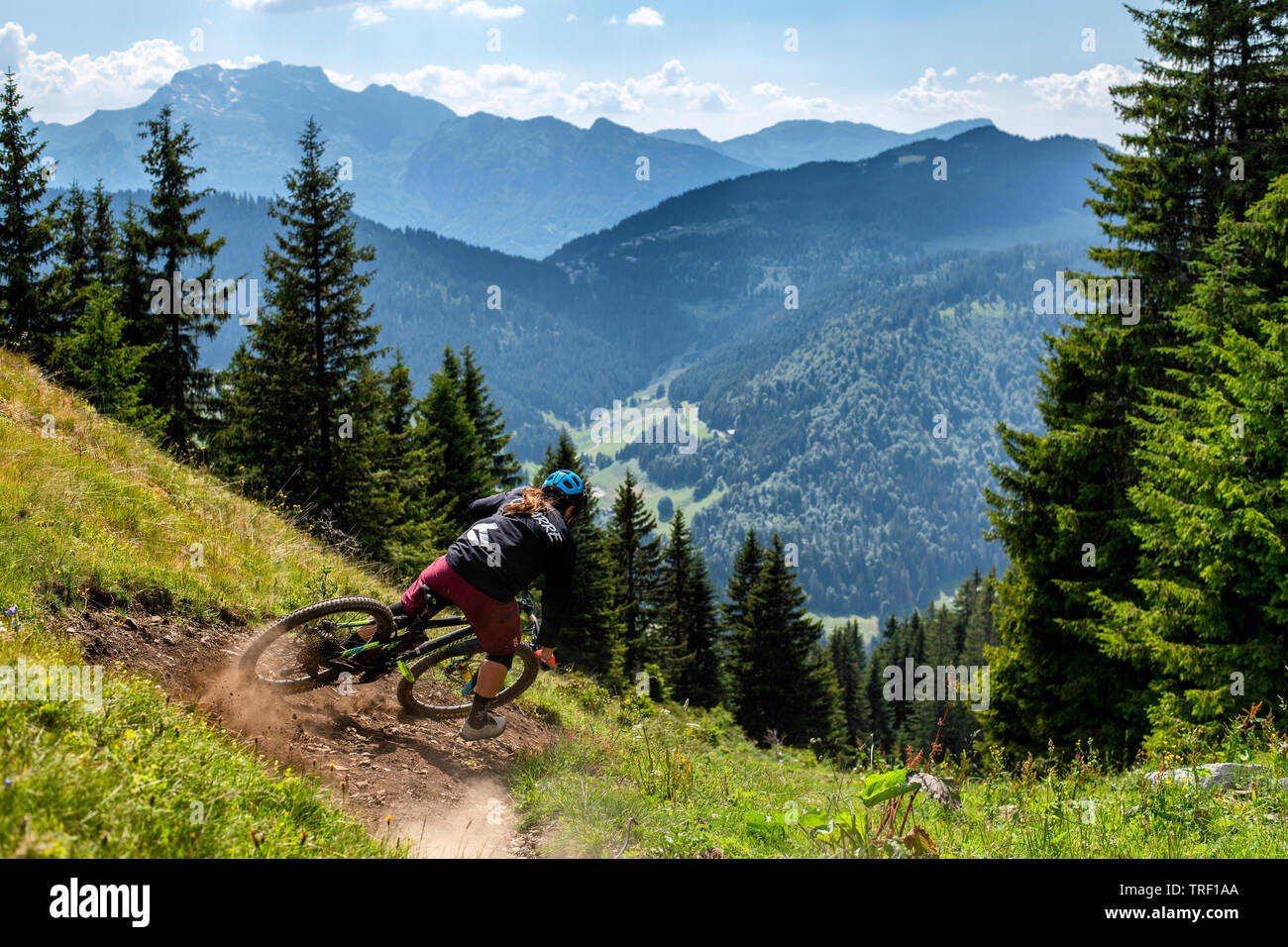 La donna corse in mountain bike su un sentiero durante l'estate francesi nella località alpina di La Clusaz, Francia. Foto Stock