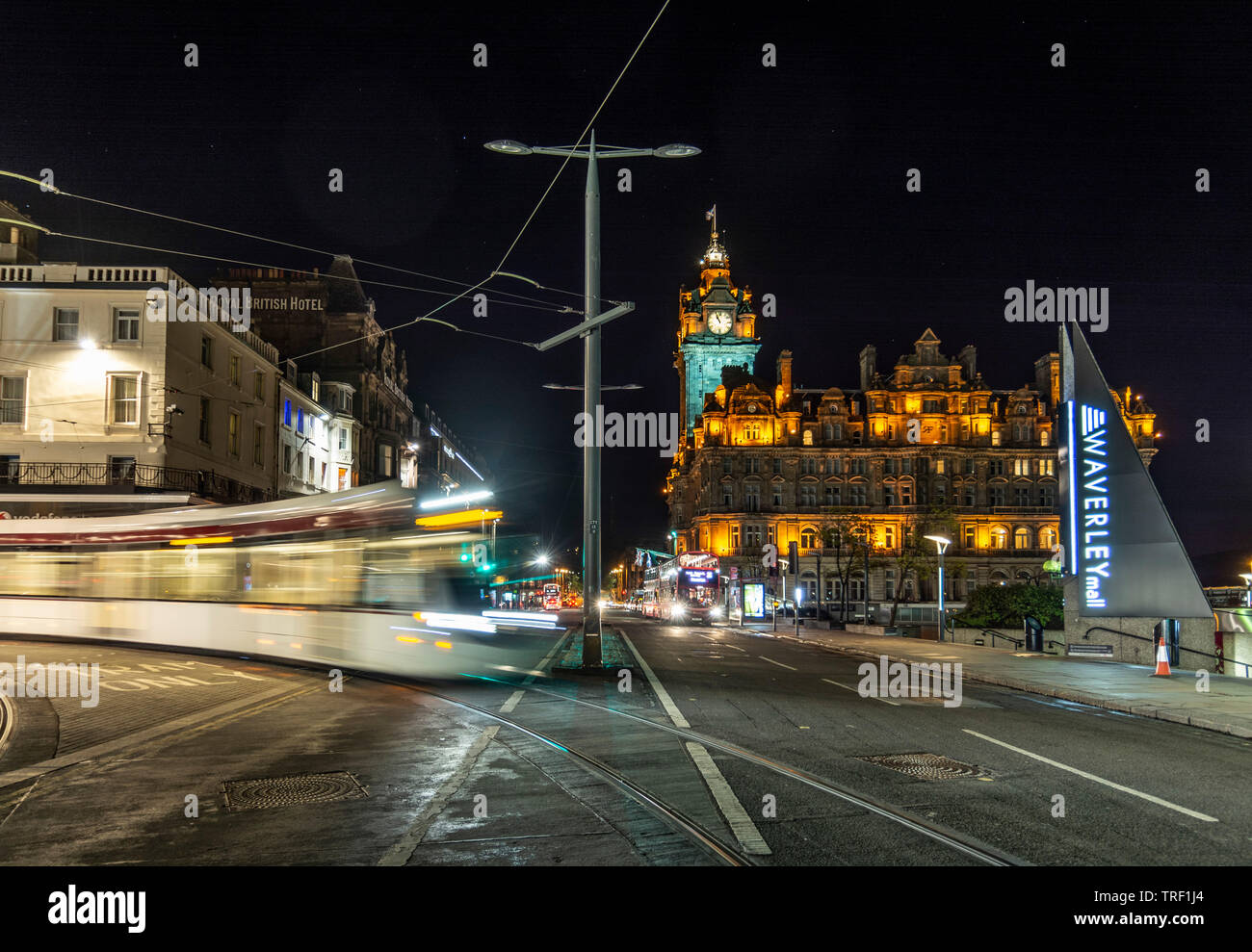 The Swish di Edinburgh tram passando sulla Princes Street di notte Foto Stock