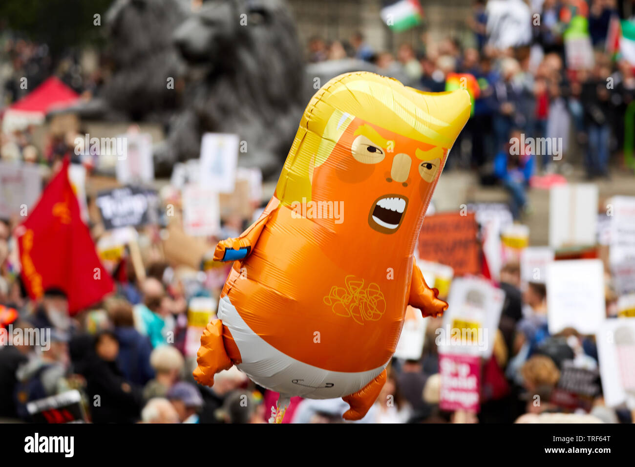 Londra, Regno Unito. - 4 Giugno 2019: un piccolo ballon beffando il presidente statunitense Donald Trump galleggia sopra la folla a Trafalgar Square durante una dimostrazione contro la sua visita nel Regno Unito. Foto Stock