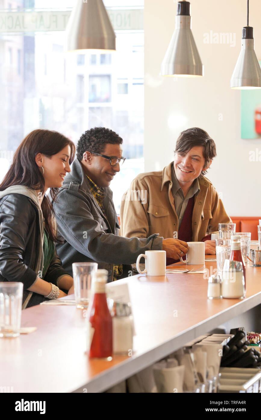 Clienti felici gruppo multietnico di persone amici avente caffè insieme al contatore in informale cafe diner ristorante Foto Stock