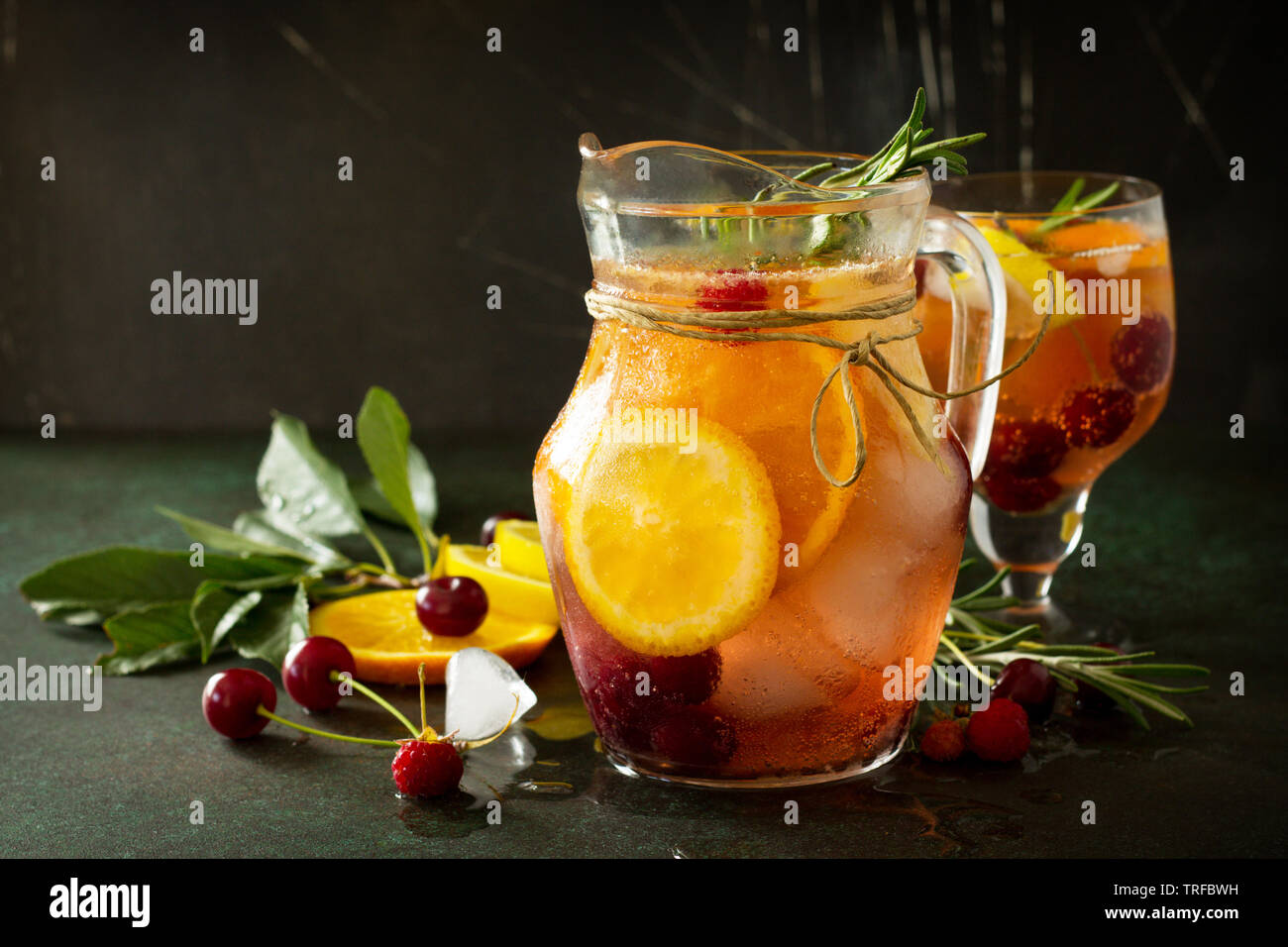 Fatti in casa vino rinfrescante sangria o punzone con frutti. La sangria cocktail con frutta fresca e bacche e rosmarino sul buio di una pietra o ardesia sfondo. Foto Stock