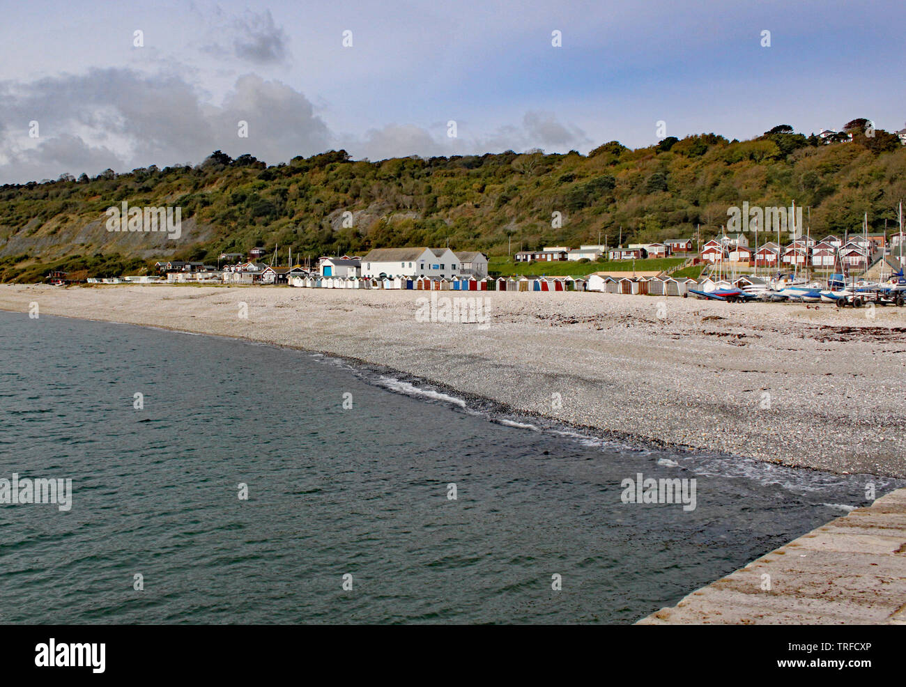 Ombrelloni sulla spiaggia di ciottoli visto dal Cobb a Lyme Regis, Dorset, Inghilterra. Foto Stock