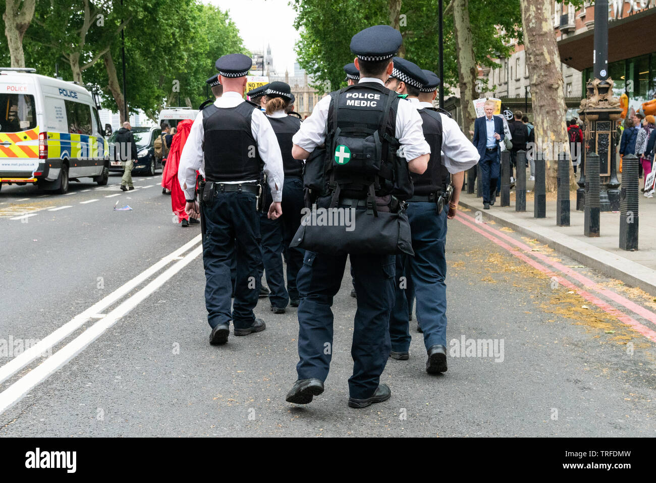 Il 4 giugno 2019. Londra, Regno Unito. Anti Trump nel rally di Westminster. Un gruppo di funzionari di polizia e forze di polizia medic seguire i manifestanti. Foto Stock