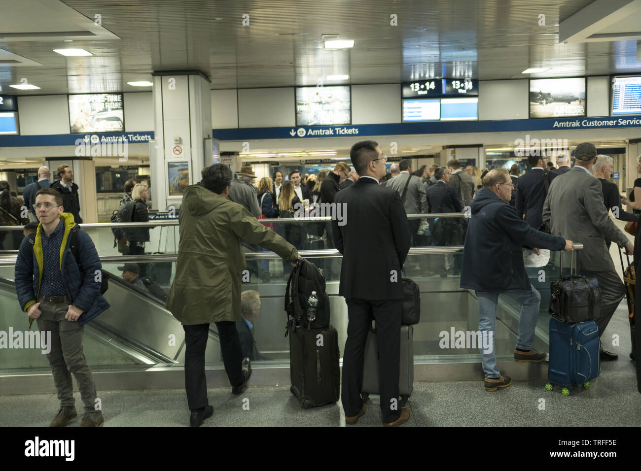 Piloti di attendere per treni ad essere annunciato a Penn Station, Manhattan, New York City. Foto Stock