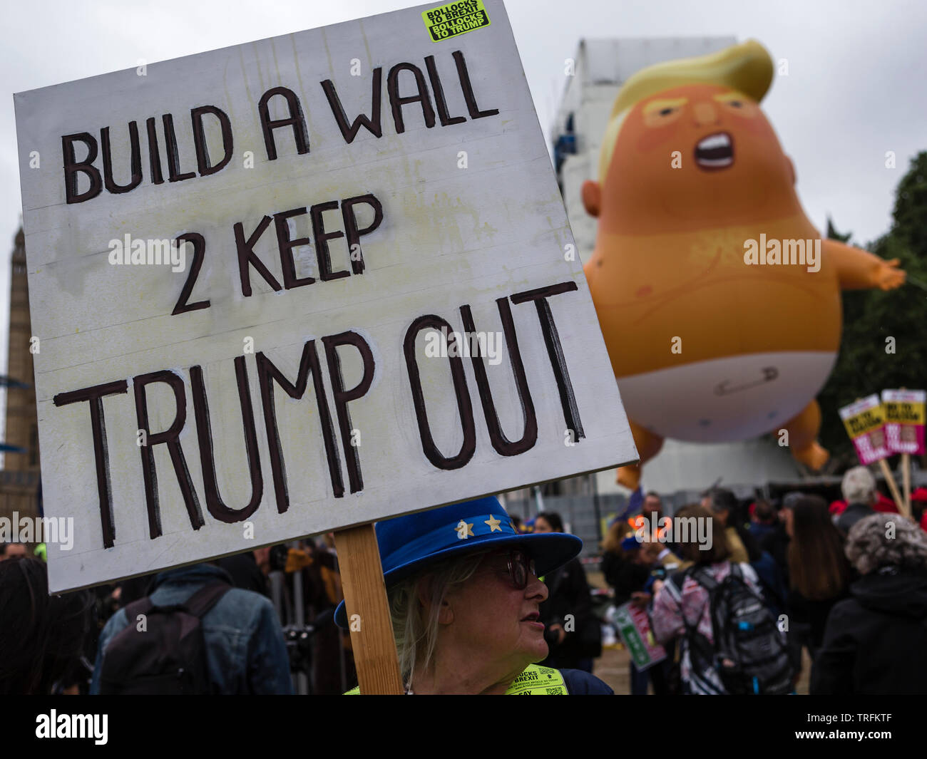 Un Trump Baby Blimp e un segno, "Costruire una parete 2 tenere Trump out' durante la Donald Trump la visita di Stato nel Regno Unito Foto Stock