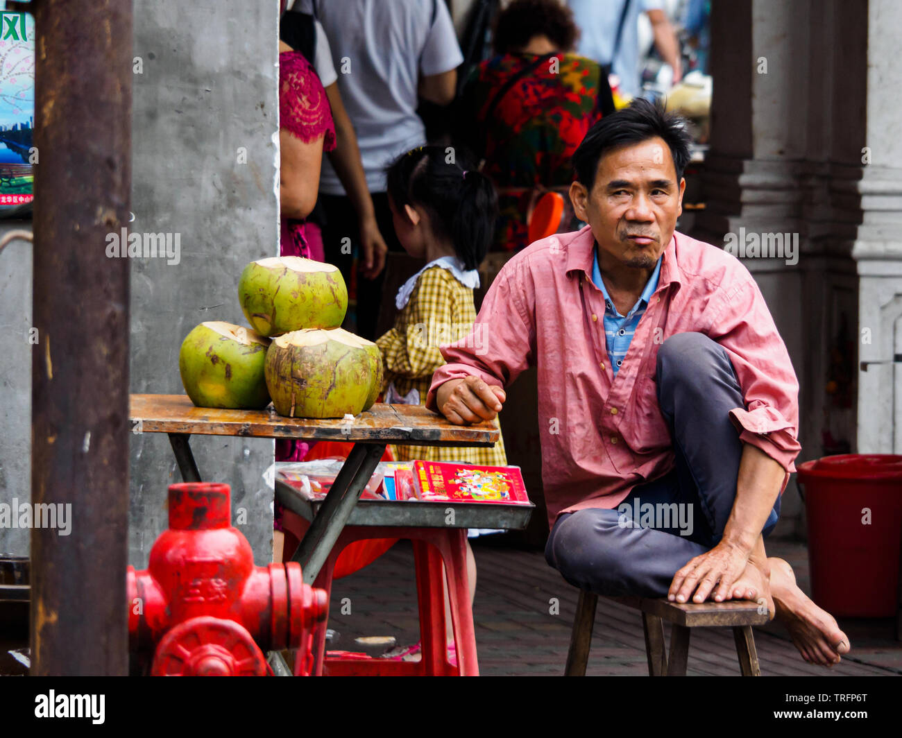 HAIKOU, Hainan in Cina - Mar 2, 2019 - un venditore ambulante vendendo acqua di cocco, un popolare bevanda locale Foto Stock