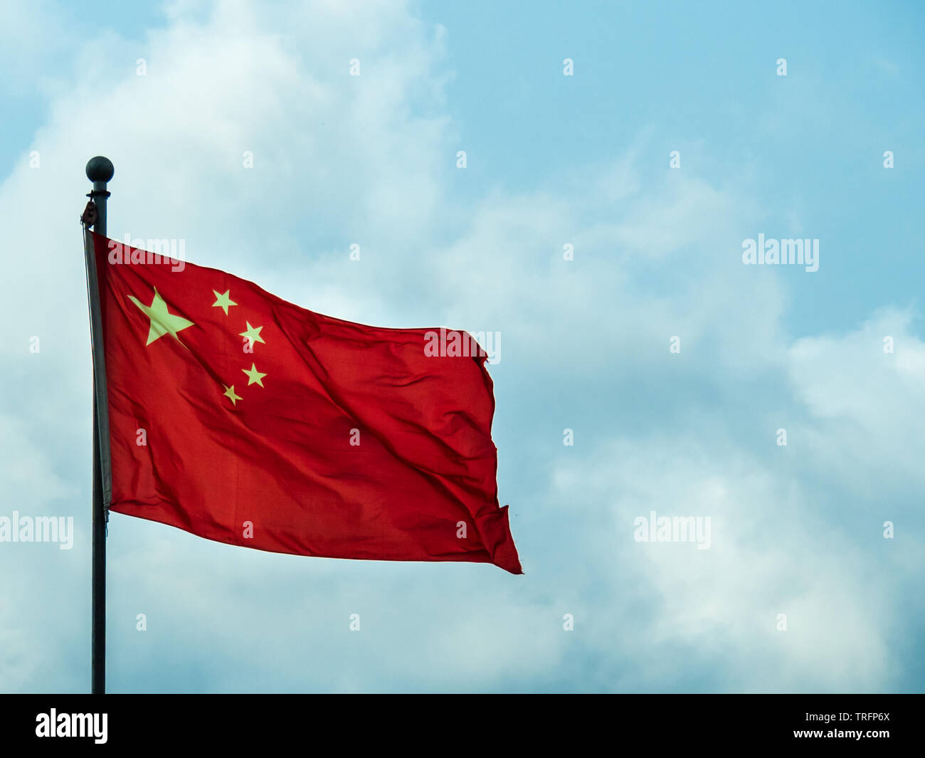 Bandiera Nazionale della gente la repubblica di cina battenti a pieno il montante contro il cielo blu Foto Stock
