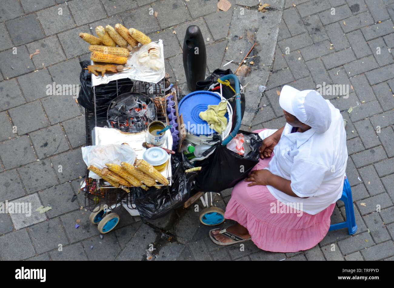 Venditore a vendere cucinata sulla pannocchia di mais a Medellin Foto Stock