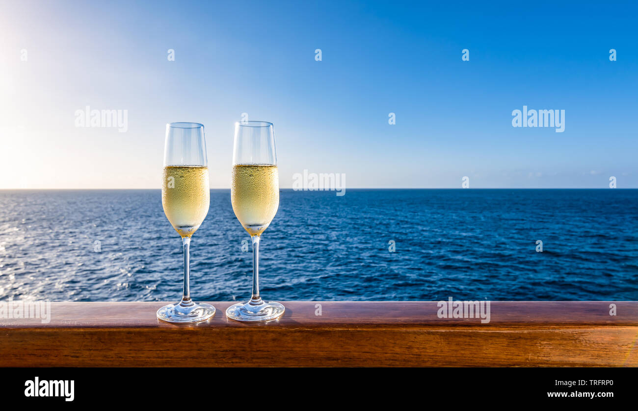 Due bicchieri di champagne sulla ringhiera in legno della nave da crociera. Sullo sfondo del mare. Luna di Miele romantica concetto. Foto Stock