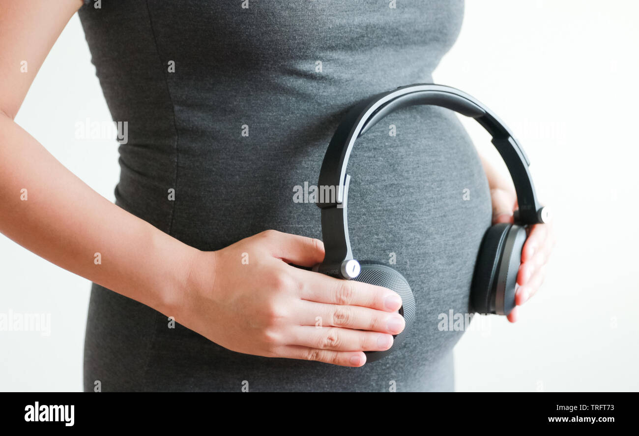 Donna incinta per ascoltare la musica con cuffie sulla pancia pancia Foto  stock - Alamy