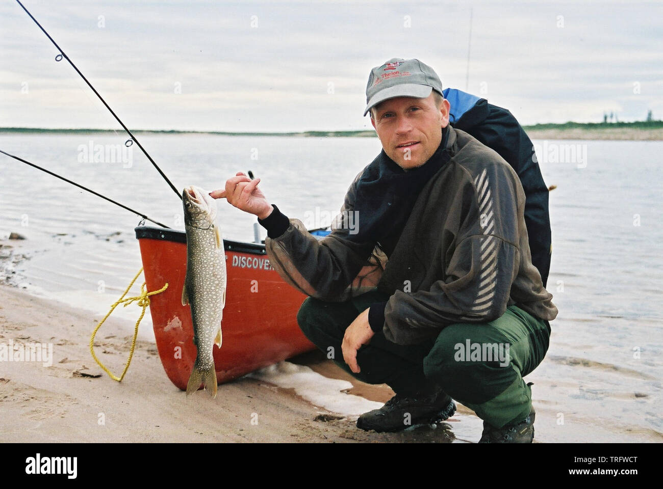 Il Norvegese Truls Andersen con una trota di lago, Salvelinus namaycush, catturati su una canoa sul fiume Thelon nei territori del nord-ovest, Canada. Luglio, 2001. Foto Stock