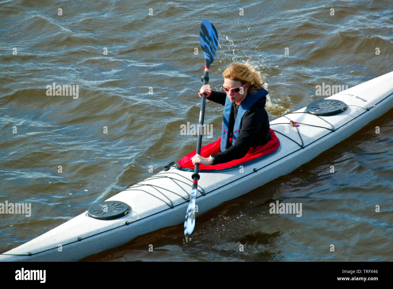 Paddler femmina in un kayak sul lago Vansjø in Østfold, Norvegia. Vansjø è il lago più grande in Østfold e i suoi dintorni di laghi e fiumi sono una parte dell'acqua sistema chiamato Morsavassdraget. Aprile, 2006. Foto Stock