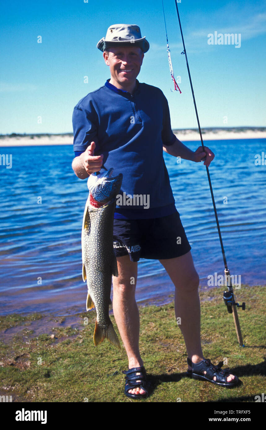 Il Norvegese Truls Andersen con una trota di lago, Salvelinus namaycush, accanto al fiume Thelon nei territori del nord-ovest, Canada. Agosto, 2001. Foto Stock