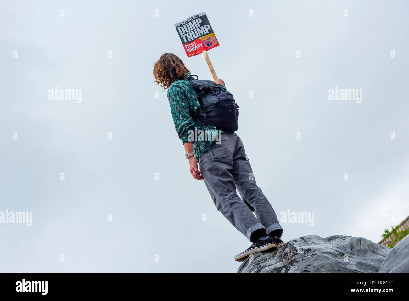 Il dimostratore in piedi su un Lions Head in Trafalgar Square durante Anti Trump dimostrazione Trump durante la visita di stato Foto Stock